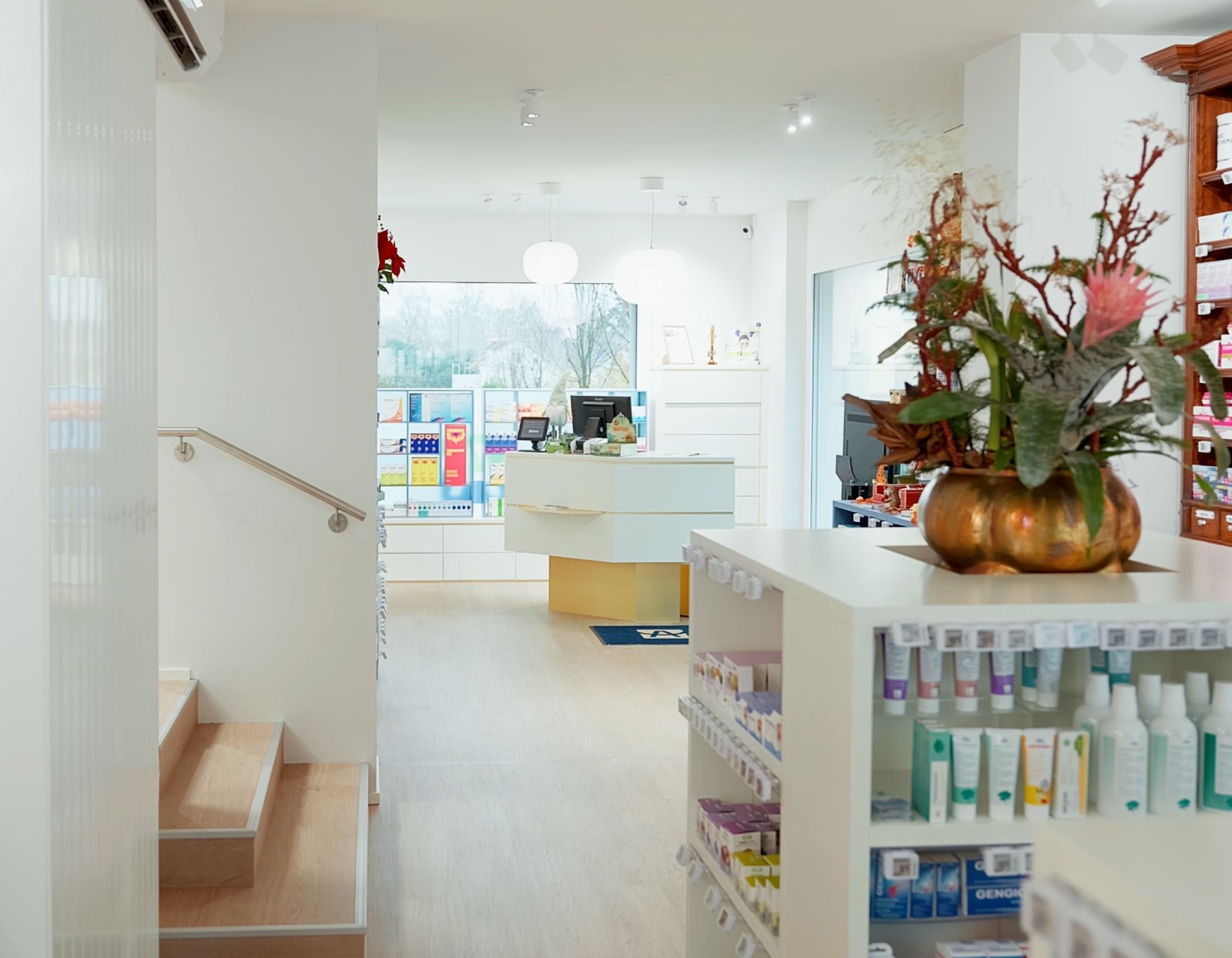 Blick in die Anklin Apotheke in Cham, Ladenraum mit Theke und Blumenschmuck