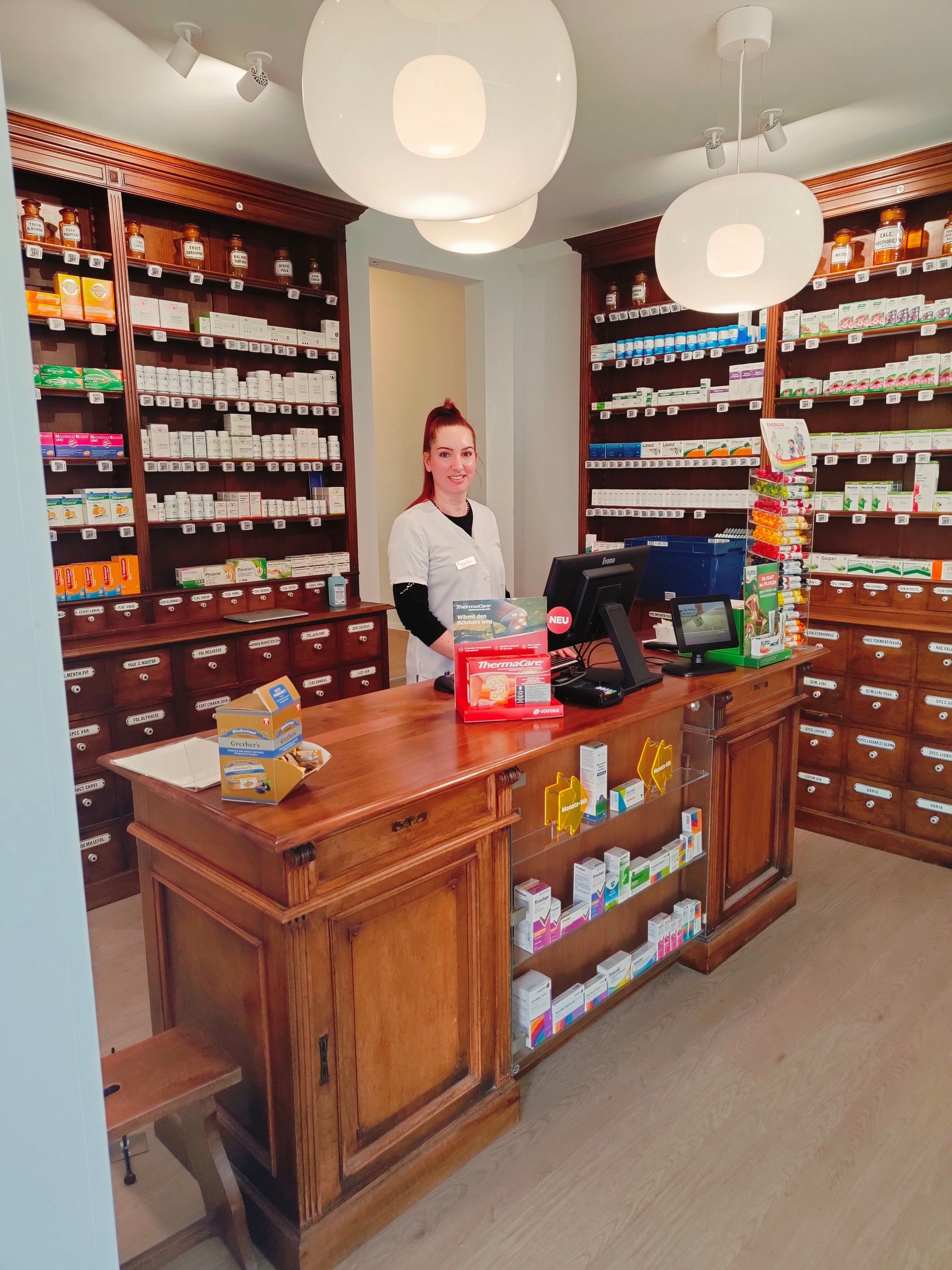 Blick in die Anklin Apotheke: historischer Ladenbau aus Holz mit Schubladenschrank hinter der Theke